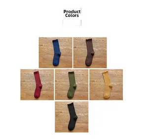 Multiple colors of women's cotton knit socks with frilled edges on wood floor