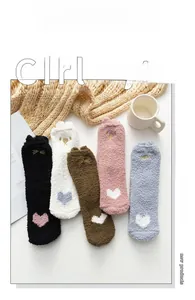 Détail de cinq paires de chaussettes en polaire corail avec oreilles d'animaux et cœurs