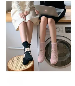 Detail von dicken Korallenvlies-Socken in Rosa- und Schwarzmustern für den Winter