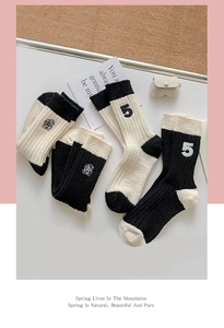 Close-up of rose and number 5 embroidery on ribbed wool blend thermal socks