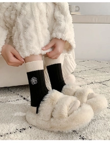 Close-up of wool socks with white camellia flower embroidery and thick warm texture