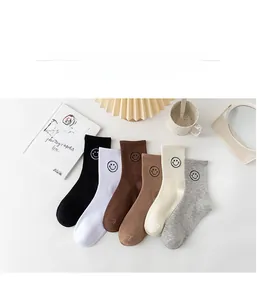 Flat lay of six pairs of cotton smile face socks in assorted neutral autumn colors