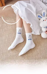 Detail of white cotton sock featuring cute rabbit embroidery and sweet lettering