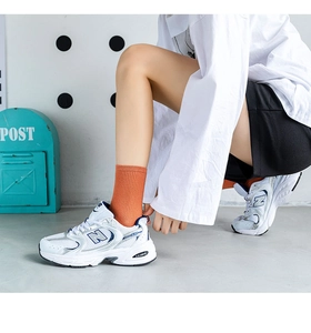 Close-up of retro white and blue athletic sneakers featuring ABZORB technology sole