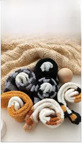 Detail view of thick coral fleece cat claw socks in various colors on a soft knit background