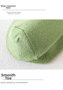 Close-up of light green knit socks showing the reinforced heel and flat-seam toe detail