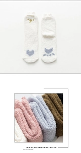 Détail de chaussettes d'hiver en polaire corail avec motifs de pattes en couleurs Morandi