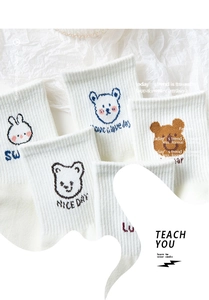 Detail of white cotton socks featuring cute bear embroidery and ribbed elastic cuffs