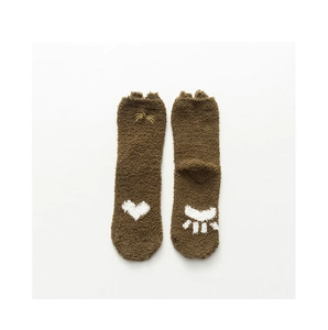 Détail de chaussettes en polaire corail marron avec oreilles de chat et broderie de patte