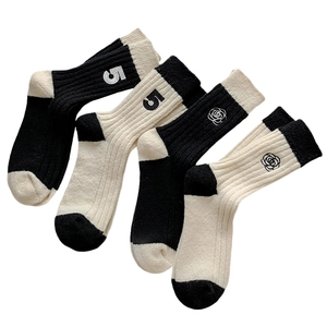 Women's thick wool socks with camellia embroidery and ribbed knit texture in black and white