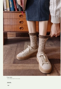 Detailed close-up of vintage brown wool socks featuring a bear pattern and ruffled cuffs