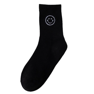 Black cotton crew socks with white embroidered smiley face and ribbed cuffs for women
