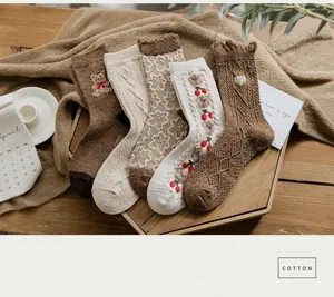 Detailed macro view of 5 pairs of thick wool socks with bear and cherry embroidery