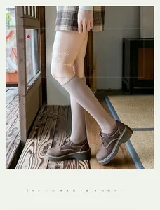 Gros plan de chaussettes hautes en maille côtelée beige avec chaussures oxford brunes