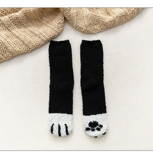 Detail of coral fleece cat paw socks with plush thick texture in black and white pattern