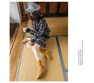 Detail of mustard yellow crew socks featuring elegant ruffle trim and ribbed texture knit