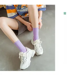 Close-up of white platform sneakers paired with light purple ribbed crew socks