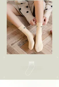Detail of cream cotton socks with black eyes embroidery and elastic ribbed cuff