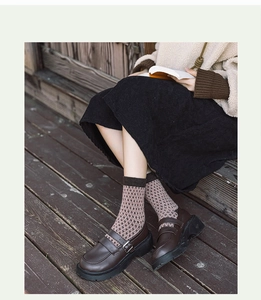 Détail de chaussettes en laine vintage à motif jacquard floral et mocassins rétro