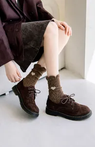 Detail of wool knit socks with heart embroidery and vintage brown suede boots