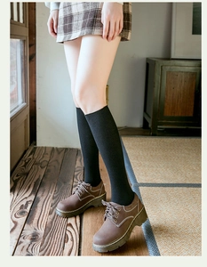Détail de chaussettes montantes côtelées noires avec chaussures vintage à plateforme