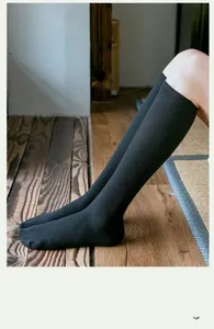 Détail de chaussettes hautes noires à côtes montrant la texture du coton mélangé