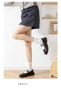 Close-up of brown double strap Mary Jane shoes paired with white floral crew socks