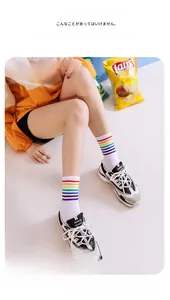 Détail de chaussettes mi-hautes en coton blanc avec rayures arc-en-ciel sur le modèle