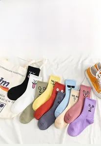Detailed flat lay of colorful cartoon socks in ten vibrant colors with funny face patterns