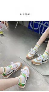 Dettaglio di calzini in cotone a righe rétro abbinati a sneakers in pelle vintage