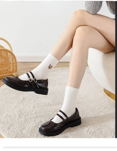 Detail of white ribbed cotton socks with bear embroidery and brown Mary Jane shoes