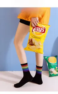 Détail de chaussettes noires en coton avec rayures arc-en-ciel sur le revers côtelé