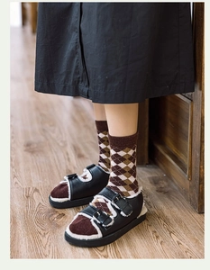 Détail de chaussettes en laine et sandales en fourrure sur sol en bois, style vintage