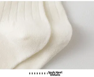 Close-up of the reinforced heel detail on off-white ribbed cotton knit socks