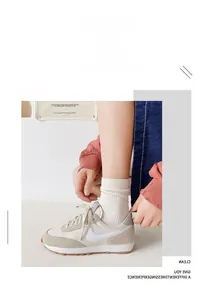 Detail of off-white mesh sneakers paired with white cotton crew socks in a casual style
