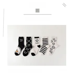 Détails de cinq paires de chaussettes en coton avec motifs souriants noirs et blancs