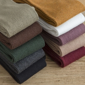 Dix couleurs de chaussettes hautes japonaises en coton côtelé sur bois naturel