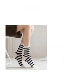 Détail de chaussettes mi-hautes classiques à rayures noires et blanches en coton doux