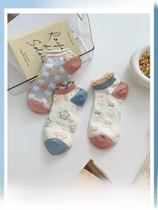 Detail view of plaid and heart pattern low-cut socks with ruffled cuffs in pastel colors