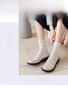 Close-up of white lace mesh socks with polka dot pattern and ruffled lettuce edges