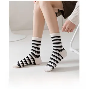 Gros plan de chaussettes mi-hautes rayées noir et blanc en maille de coton sur pieds