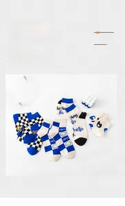 Close-up of crew socks featuring Klein blue checkerboard and smiley face patterns