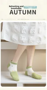 Detail of green floral embroidery and ruffled edge on cotton crew length socks