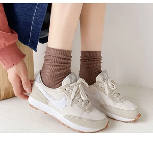 Detail of coffee brown ribbed knit crew socks with a classic vertical stripe texture