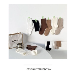 Detail view of ribbed knit crew socks in earth tones like cream, coffee, and caramel