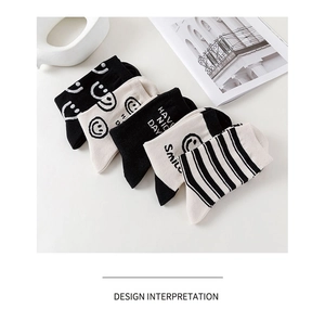 Cinq paires de chaussettes en coton noir et blanc avec motifs sourires et rayures