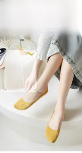 Close-up of yellow ice silk low cut socks with cat pattern on paper stand