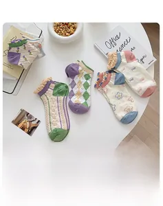 Detail of five pairs of pastel socks with ruffle cuffs and assorted cute patterns