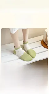 Close-up of green and white cotton socks featuring floral patterns and wavy edges