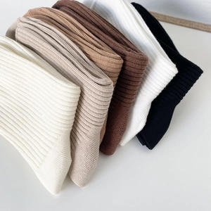 Ribbed knit cotton crew socks in six earth-tone colors arranged in a neat diagonal layout